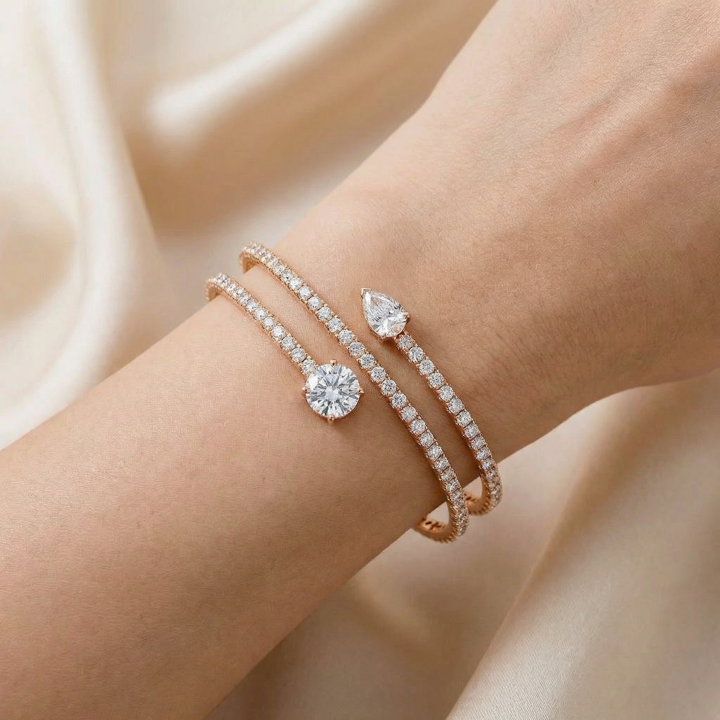 Close-up of a wrist wearing two diamond bracelets on a soft beige background