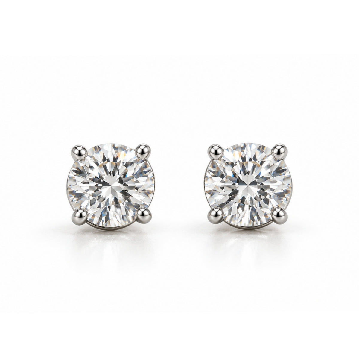 A pair of round-cut diamond stud earrings in a four-prong setting, shown on a clean white background.