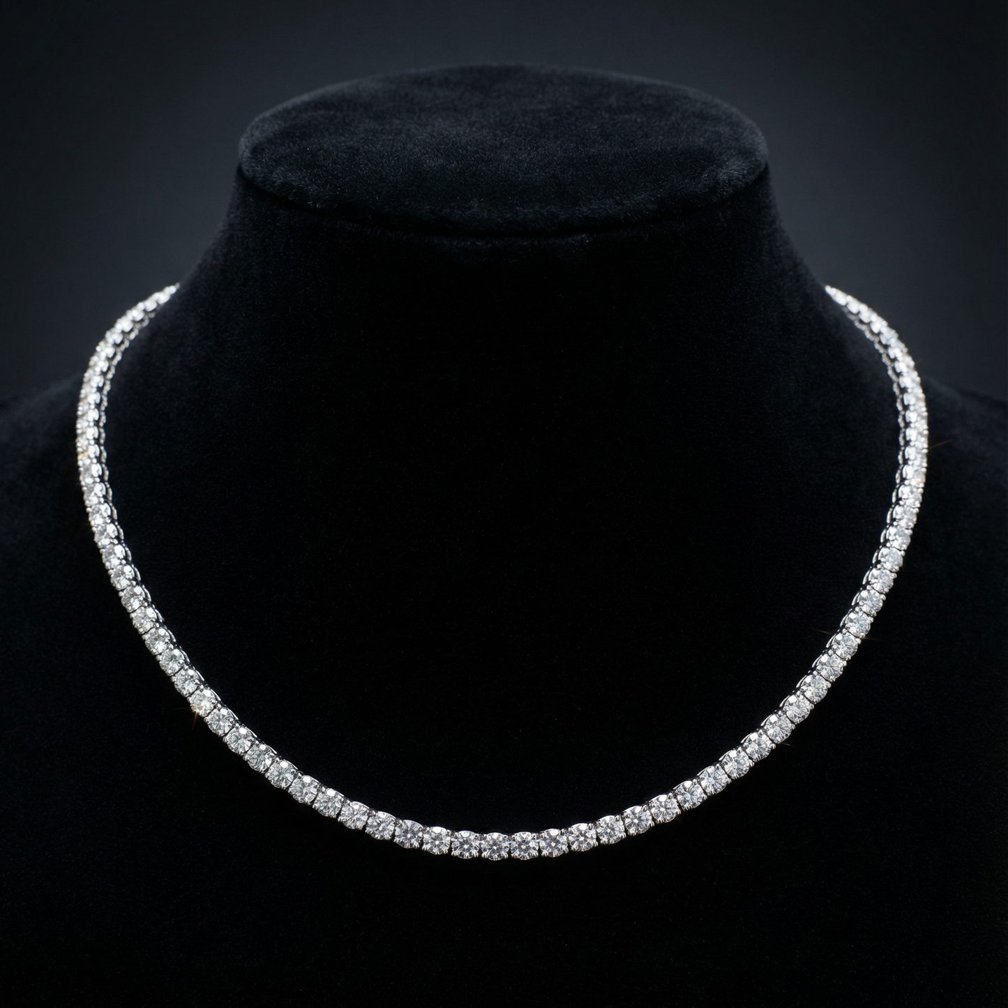 Diamond necklace on a black velvet stand against a dark background