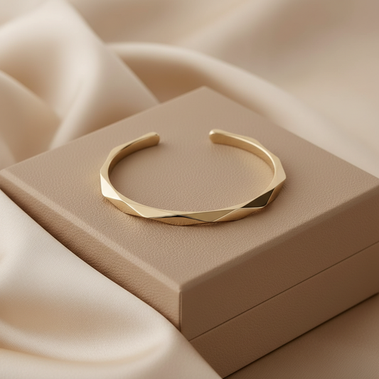 Gold bracelet on a beige box with a soft beige fabric background