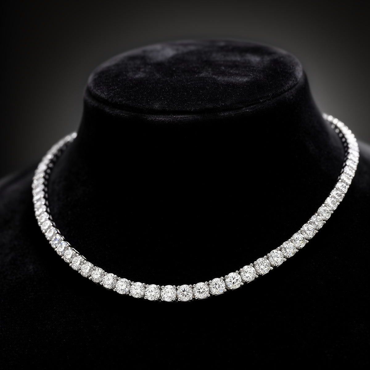 Diamond necklace on a black velvet stand against a dark background