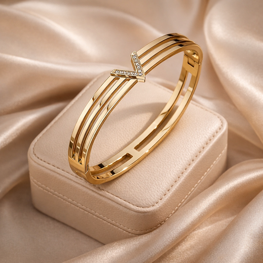 Gold bracelet with diamond accents on a beige satin surface