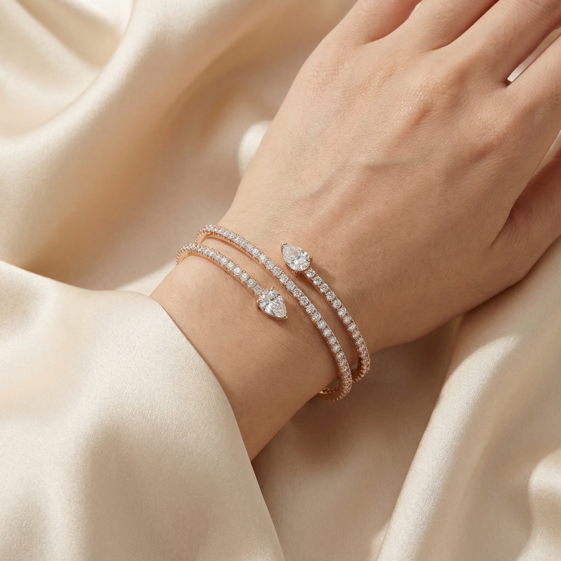 Close-up of a hand wearing rose gold bracelets on a beige fabric background