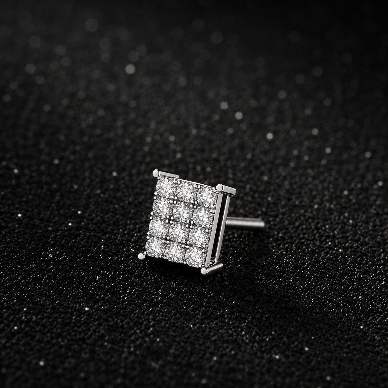 Silver square-shaped earring with clear stones on a black textured background