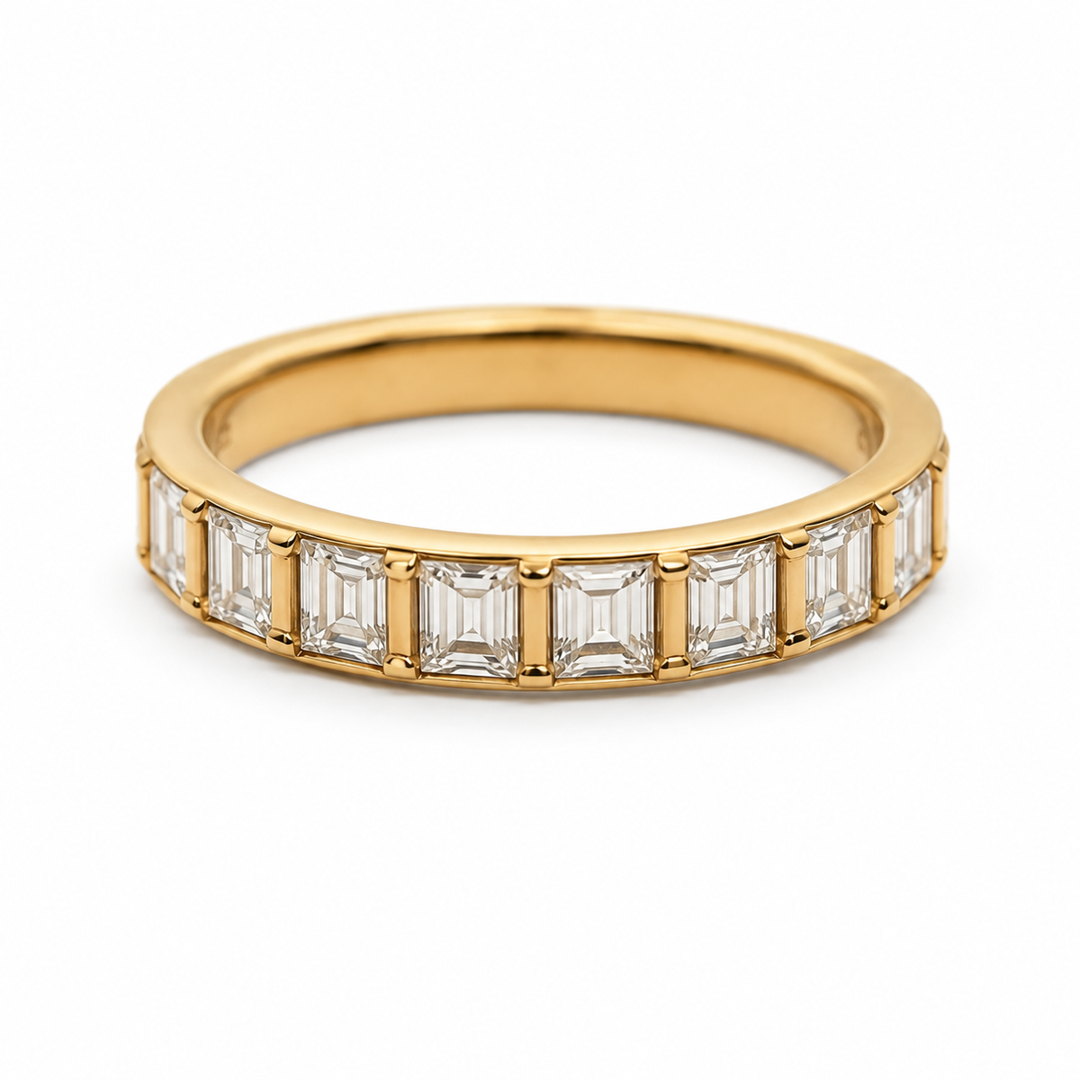yellow gold eternity ring featuring a row of baguette-cut clear gemstones